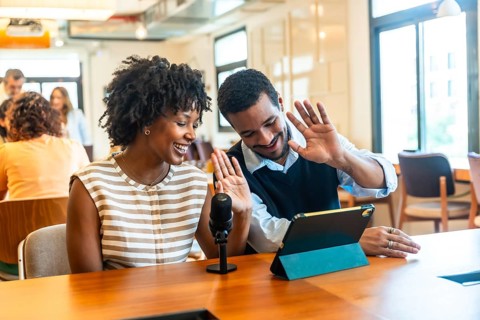 Diverse colleagues creating digital content together, streaming a live video podcast from their