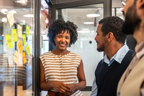 Smiling african american woman presenting ideas while discussing project strategies with diverse
