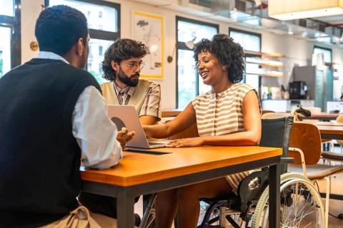 Diverse colleagues collaborating around a modern coworking table, smiling and brainstorming with a