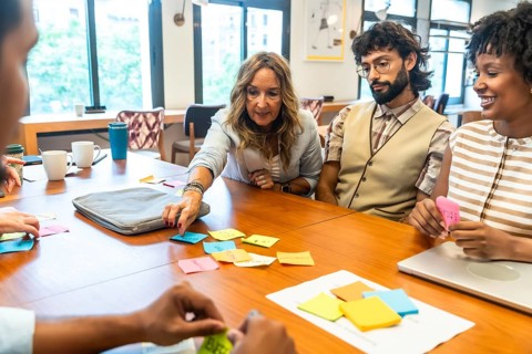 Diverse team of professionals collaborating, strategizing, and sharing concepts using colorful