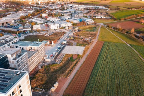 Outskirts of town with fields and construction areas, roads lead through rural surroundings, new