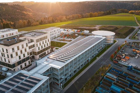 Industrial complex with solar systems next to green fields in the evening light, new hospital, Calw