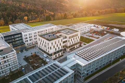 Modern buildings with solar panels on the roof, surrounded by landscape at sunset, new hospital,