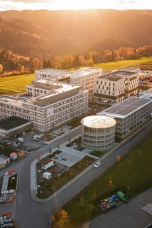 Modern buildings in rural landscape with forests and fields at sunset, aerial view, new hospital,