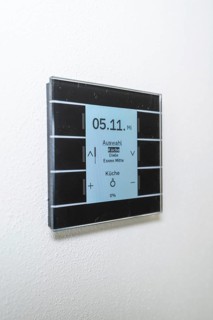 A modern switch on the wall with a blue display