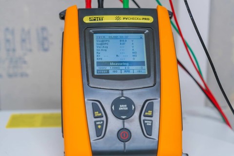 Measuring device with cables shows various electrical measurements on a display