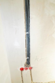 Black cable ducts inserted into the wall, prepared for electrical installation