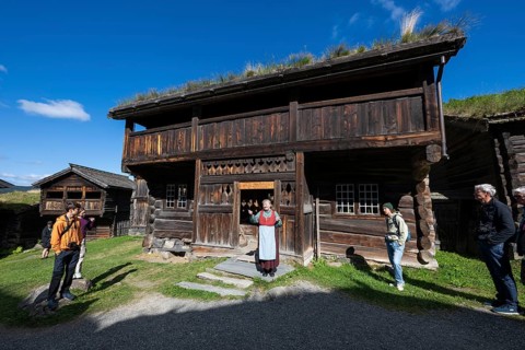 Tourist guide in traditional traditional costume and visitor, Bjørnstad, farm from Vågå, Maihaugen