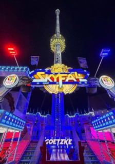Colourfully illuminated Skyfal free fall tower at night at the All Saints Fair, Soest, North