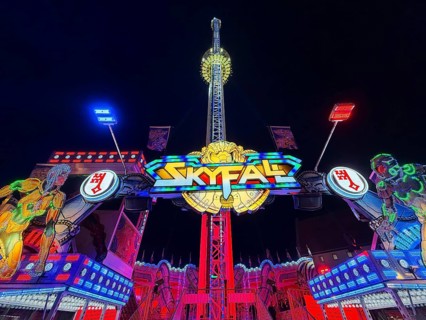 Colourfully illuminated Skyfal free fall tower at night at the All Saints Fair, Soest, North