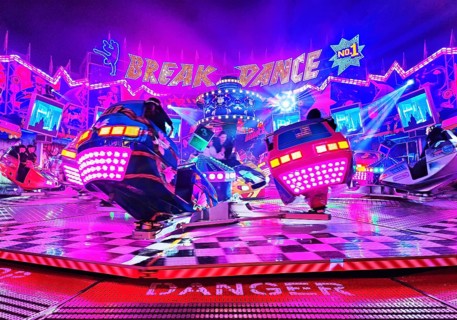 People in the colorful illuminated break dance ride at night at the All Saints Fair, Soest, North