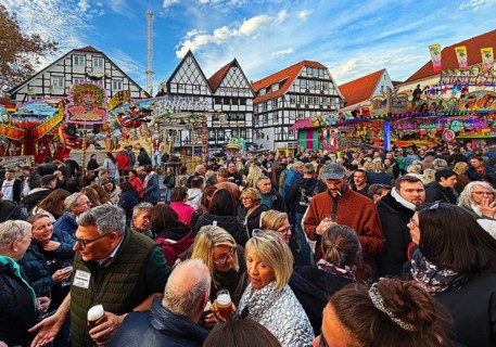 Many people at the All Saints Fair in front of half-timbered houses, largest old town fair in
