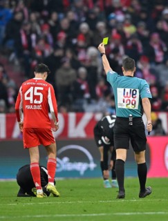 Referee Sven Jablonski showing Aleksandar Pavlovic FC Bayern Munich FCB (45) yellow card yellow