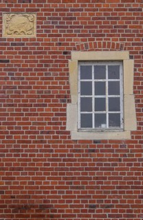 A rectangular window and a coat of arms in a red brick façade, Düstermühle, Münsterland, North