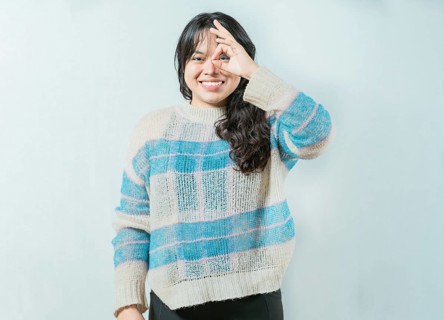 Beautiful asian woman making OK gesture looking through fingers isolated. Smiling asian girl making