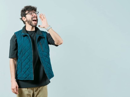 Young man in glasses shouting a promotion isolated. Handsome guy shouting an announcement
