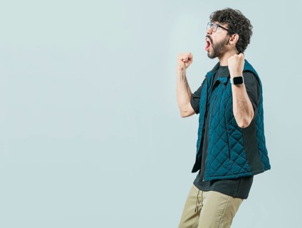 Happy guy with sunglass celebrating something. Excited young man celebrating looking at camera