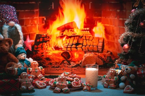 Christmas scene with cookies and milk in front of a fireplace with toys and decoration