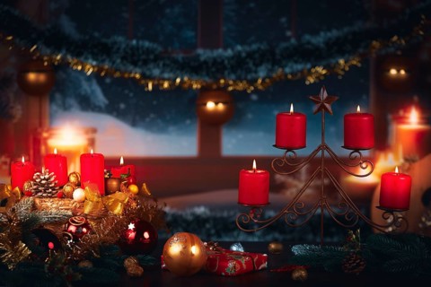 Festive Christmas decoration with red candles and gifts in front of a winter window