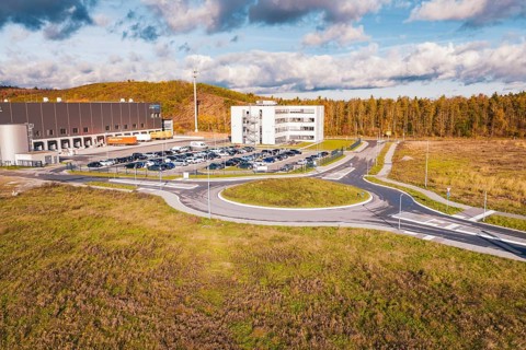 Building complex and roundabout in autumn landscape under blue sky, new Lindenrain industrial park,