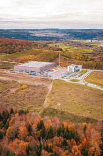Large warehouse in the middle of a hilly landscape with autumn trees, new Lindenrain industrial