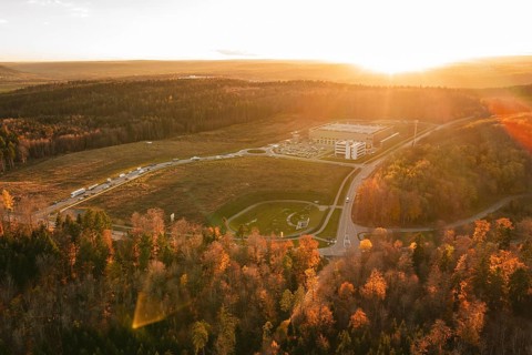 Sunset over a building in an autumn forest area with golden lighting, new Lindenrain industrial