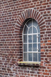 Old brick wall with an arched window and a rustic architectural style, Düstermühle, Münsterland,