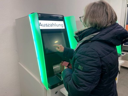 Elderly woman at an EC cash machine, operates screen, has money withdrawn, BW-Bank,