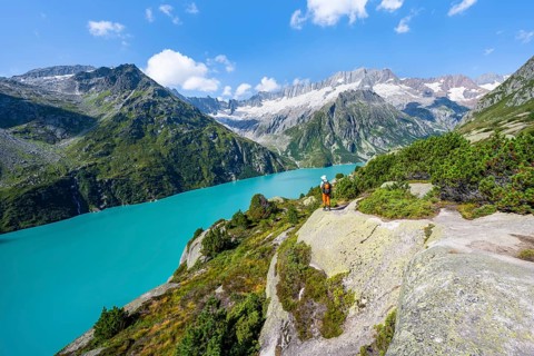 Mountaineers in front of picturesque mountain landscape, turquoise-blue mountain lake