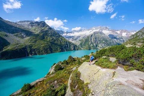 Female mountaineer in front of picturesque mountain landscape, turquoise-blue mountain lake