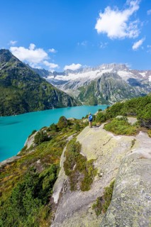 Female mountaineer in front of picturesque mountain landscape, turquoise-blue mountain lake