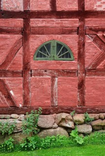 Green window in a wall in a red half-timbered house in Den gamle by, The old Funen village, open