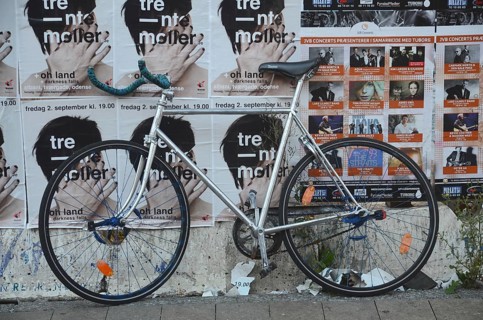 Racing bike set against a wall filled with posters in Odense, Fyn, Funen island, Denmark,