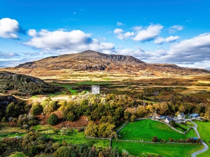 Autumn colours over Castell Dolwyddelan and Eryri Mountains from a drone, Snowdonia, Conwy County