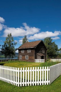 Old farmhouse surrounded by a white-painted fence, Maihaugen open-air museum with houses and