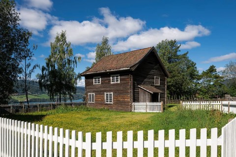 Old farmhouse surrounded by a white-painted fence, Maihaugen open-air museum with houses and