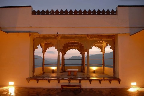 View through illuminated, traditional arched architecture of a slightly elevated terrace of