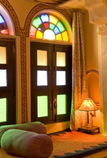 Interior with colorful window, cozy seating area with pillows and lamp, Karni Fort Bambora Palace