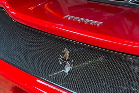 Close-up cutout detail part of red rear rear end of sports car Supercar Ferrari with logo trademark