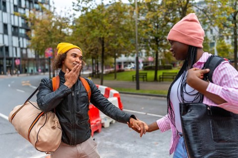 Young diverse couple holding hands while walking on an urban street, exploring the city together
