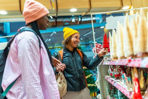 Young Mixed-race couple happily shopping for festive holiday decorations, selecting small christmas