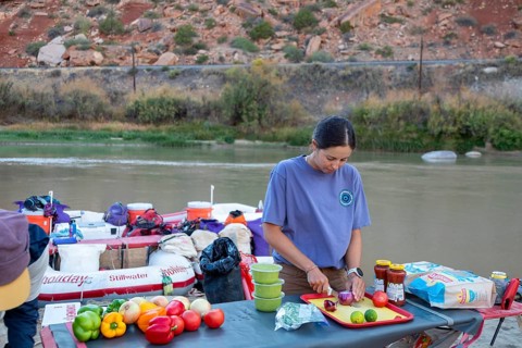 Loma, Colorado - A river guide prepares a meal during a rafting trip through the Colorado River's