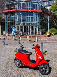 Red Vespa parked in front of the entrance to the Einstein Center for Mathematics building at the