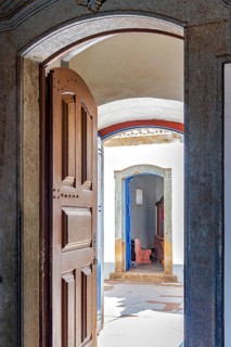 Open Baroque church door overlooking the courtyard and entrance to a chapel in Congonhas