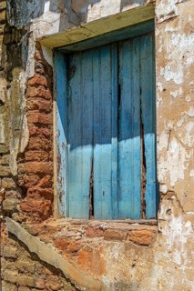 Wooden window and wall of an old, abandoned house, destroyed by time