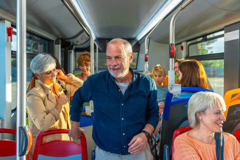 Diverse group of people, including seniors and children, commuting and traveling together inside a