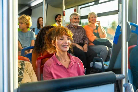 Diverse group of smiling passengers men, women, children and seniors relaxed and chatting on a