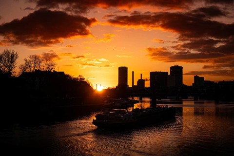 The sun sets behind the Main and Frankfurt Westhafen Tower, Alte Brücke, Frankfurt am Main, Hesse,