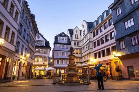 A tourist photographs the Friedrich-Stotlze bust at the chicken market in Frankfurt's New Old Town,