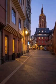 The lights in the shops of Frankfurt's New Old Town and the top of St. Bartholomew's Cathedral glow